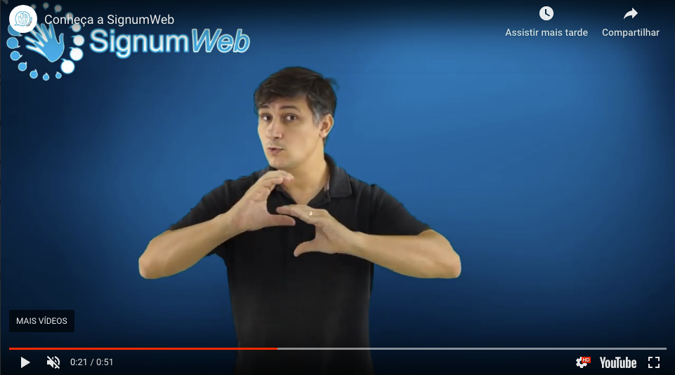 Imagem que dá acesso a um vídeo em que Felipe Barros, idealizador da Signumweb aparece, sinalizando o seu nome em Libras. Ele está usando camisa polo azul.